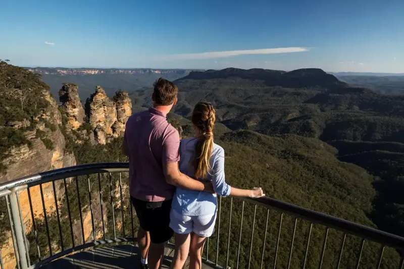 Two visitors looking across the Three Sisters